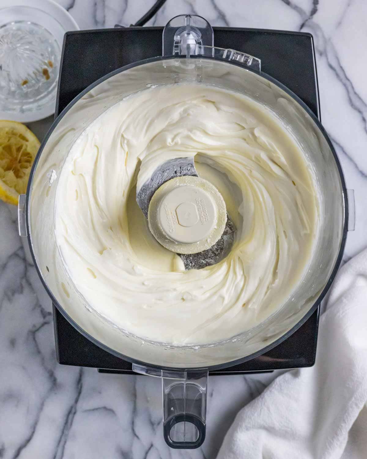 Food processor with whipped ricotta dip fully mixed.