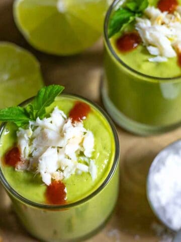 Gazpacho in 2 shot glasses topped with crab, mint leaves and cocktail sauce.