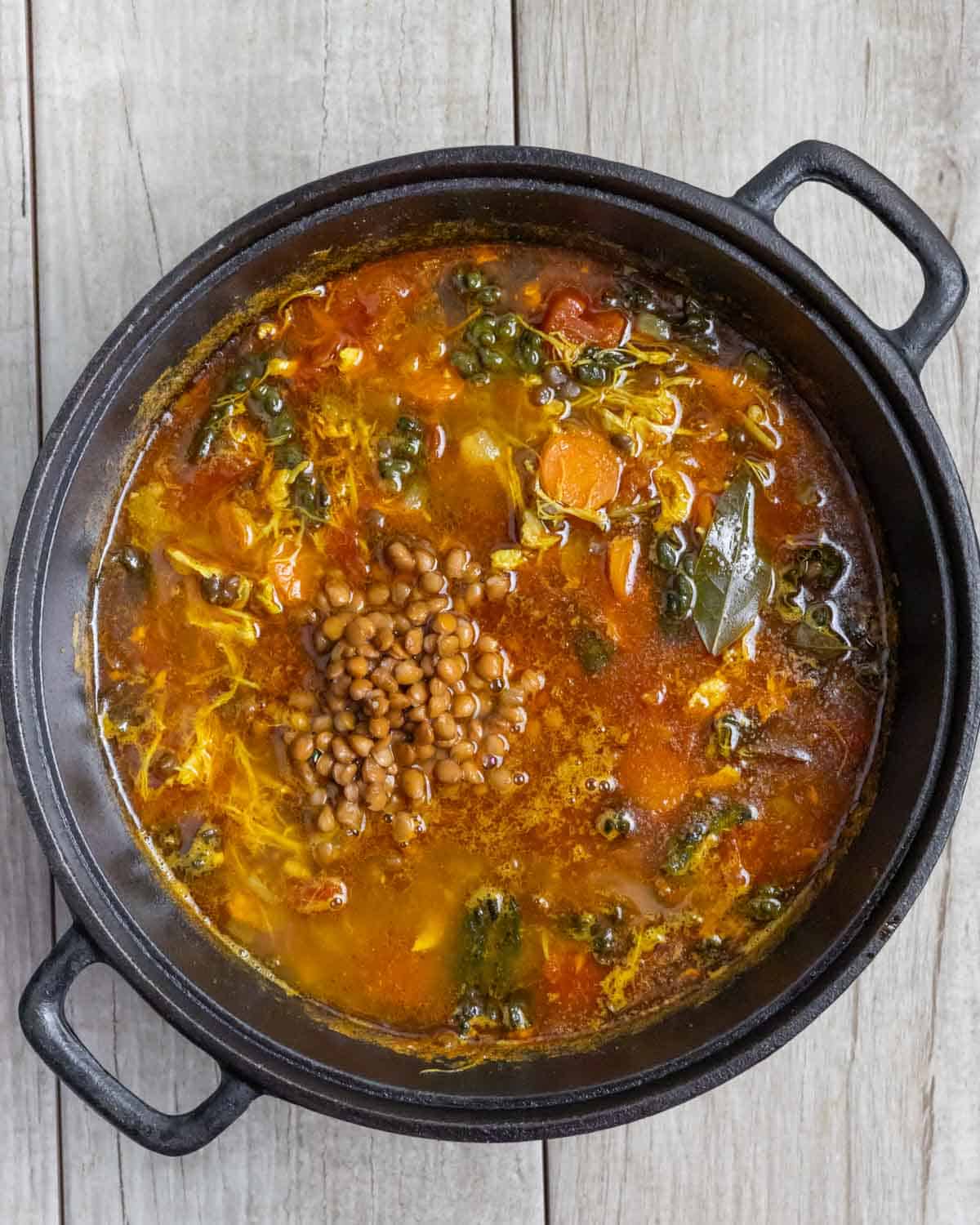 Soup pot with lentils added to other turkey lentil soup ingredients.