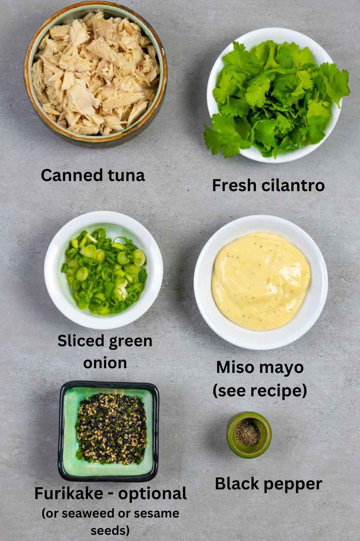 Ingredients for miso tuna salad in small bowls on a grey board with black text labels.