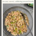 Bowl of miso tuna salad with a serving spoon in it on a grey board with a small bowl of furikake.