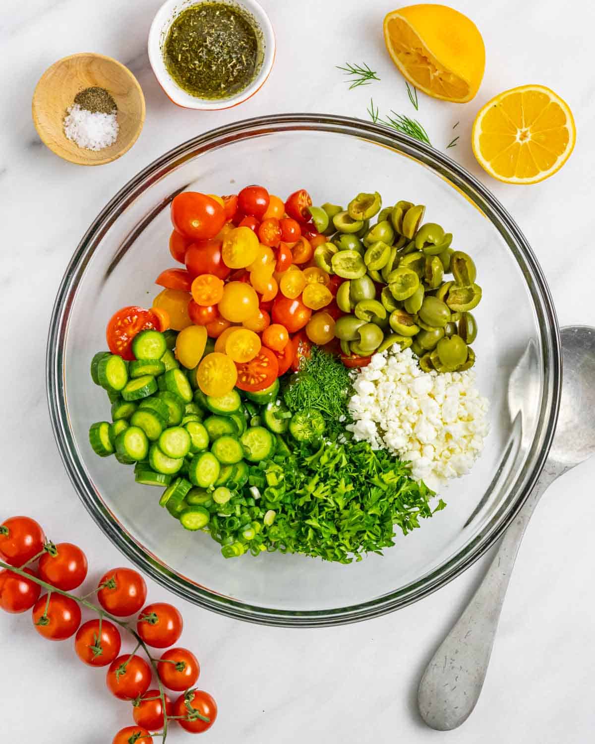 Ingredients for cucumber tomato salad chopped and in a clear bowl ready to mix.