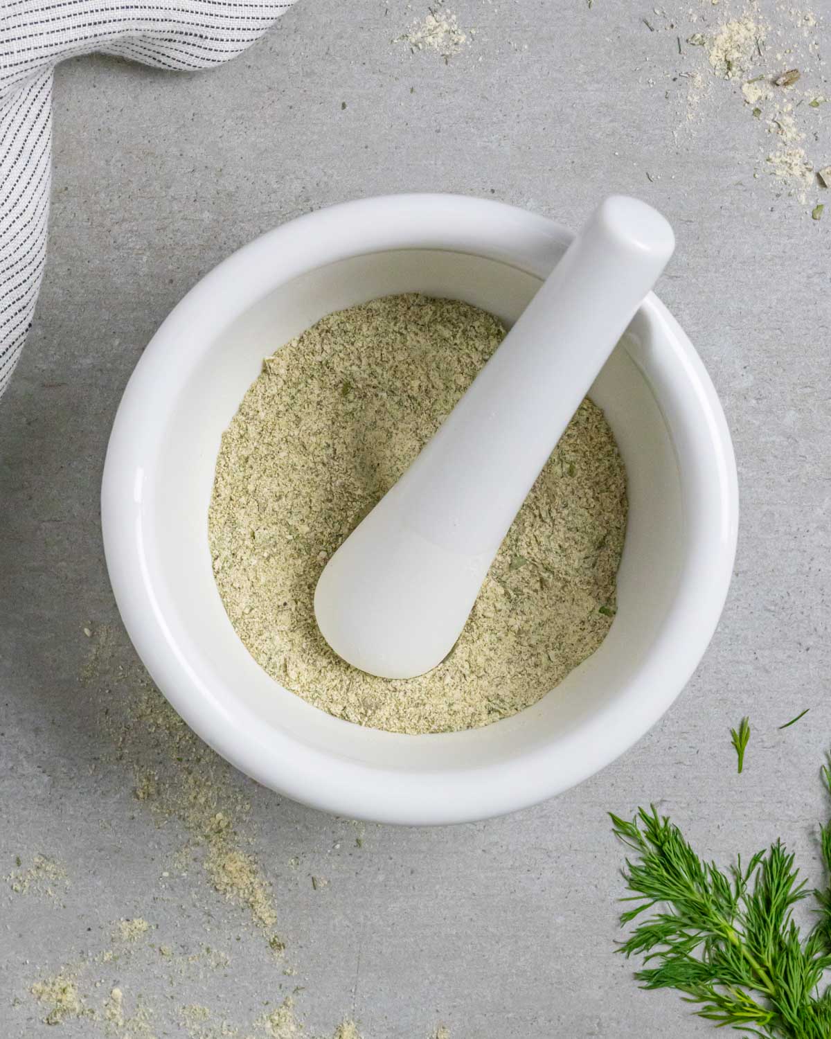White mortar and pestal with homemade ranch seasoning mix.
