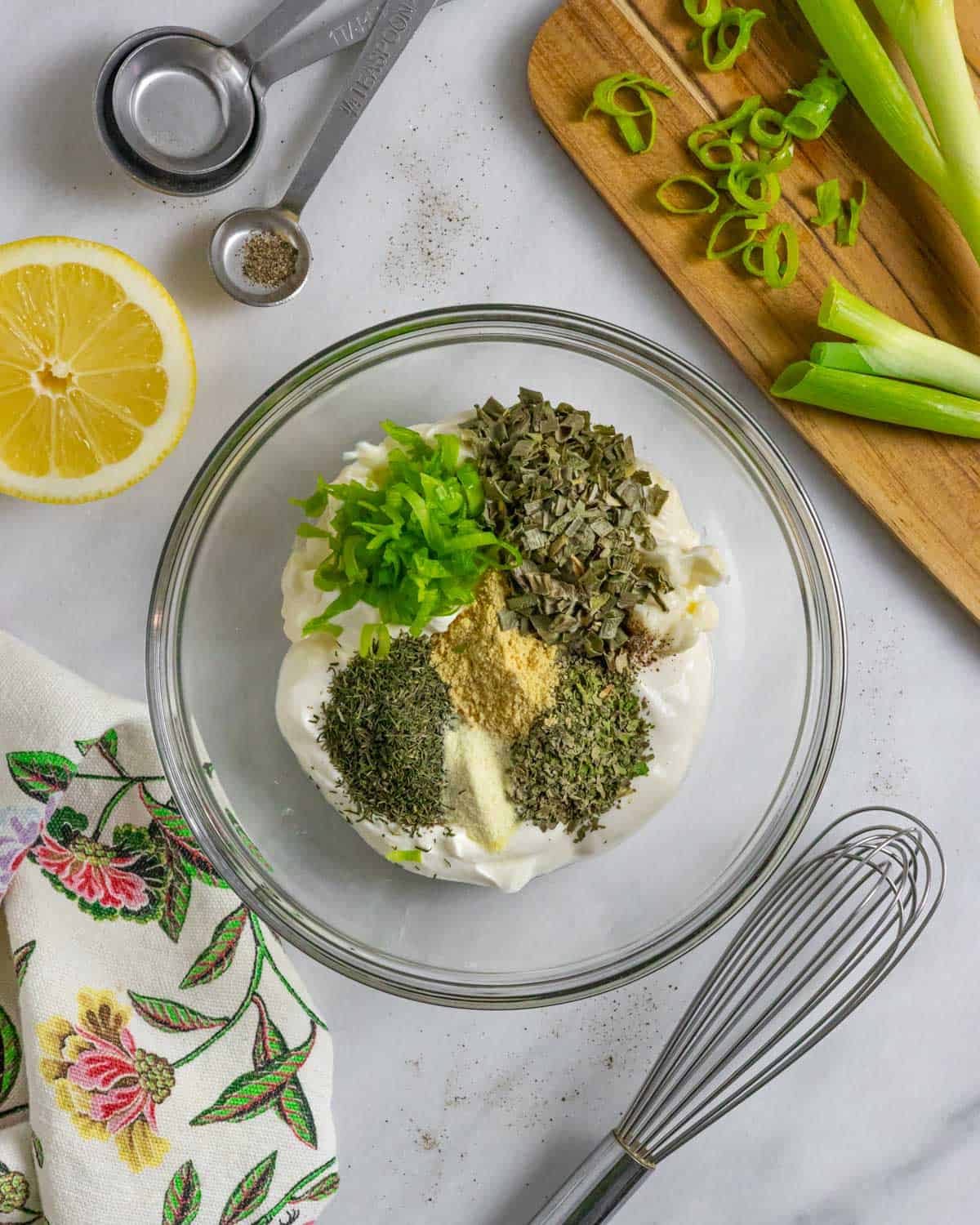 Ranch dressing and dip ingredients piled separately in a glass bowl ready to mix.