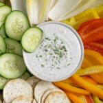 Cottage cheese ranch dressing in a bowl on a platter of dipping veggies.