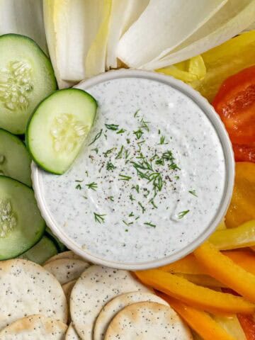 Cottage cheese ranch dressing in a bowl on a platter of dipping veggies.