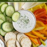 Healthy ranch dip with cottage cheese in a bowl on a platter of veggies and crackers.