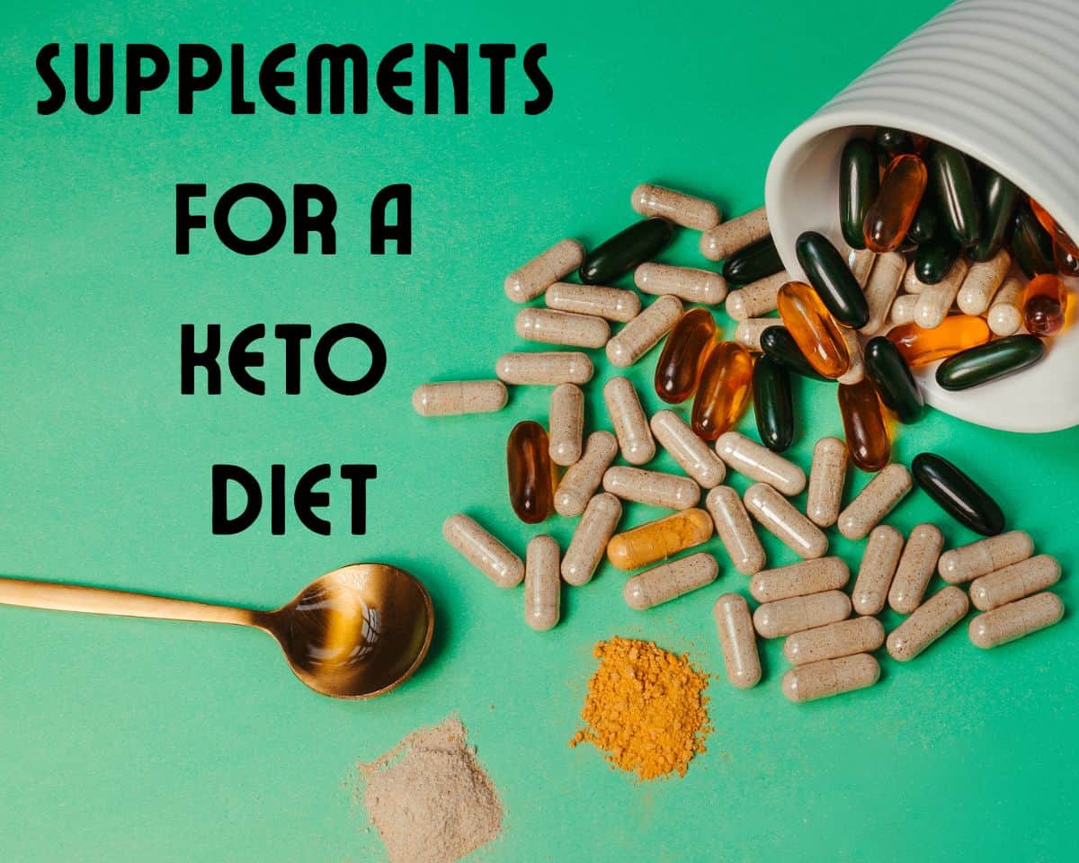 Multicolored capsules coming out of a cup and a spoon on green surface and title supplements for a keto diet
