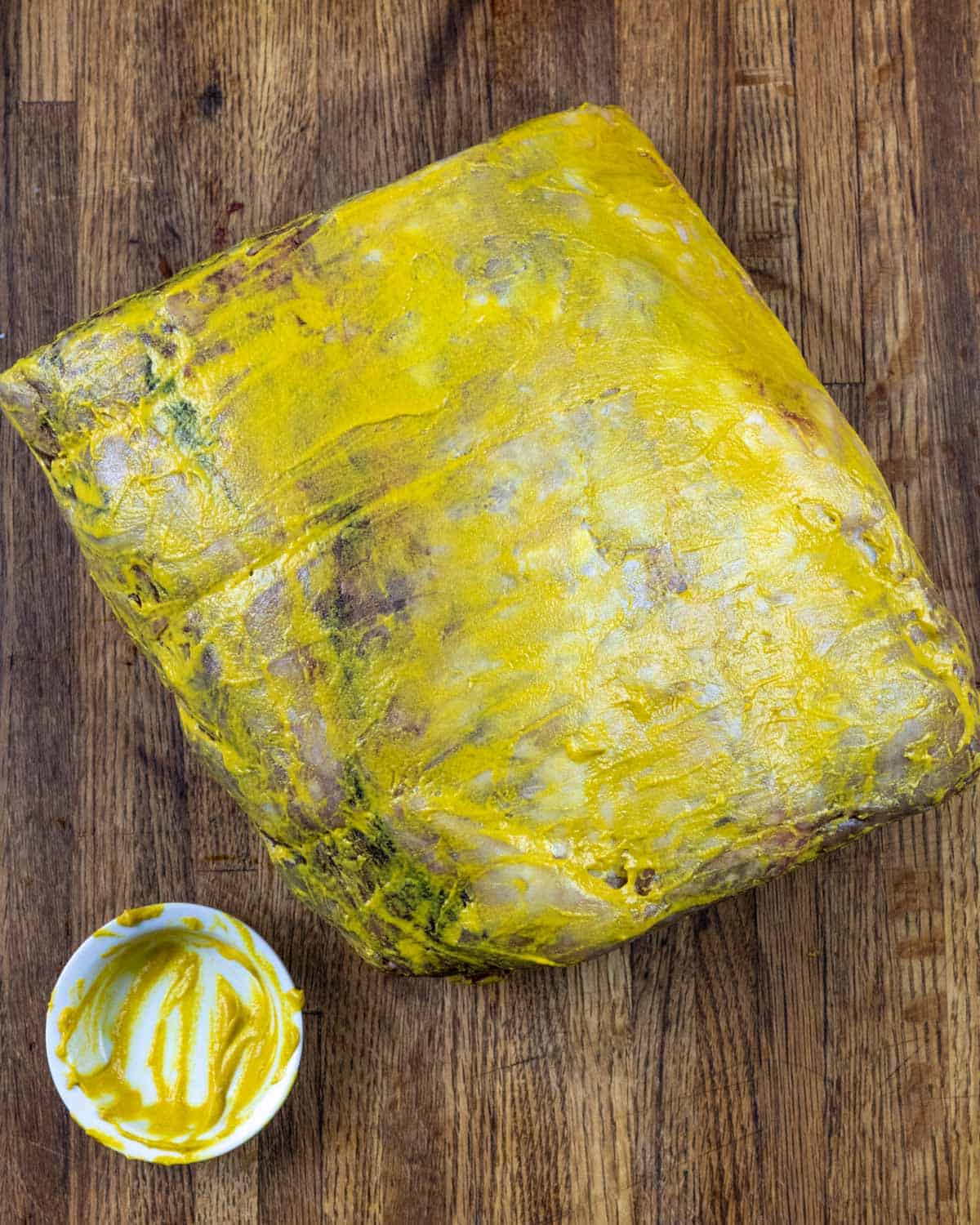 Prime rib roast coated in yellow mustard
