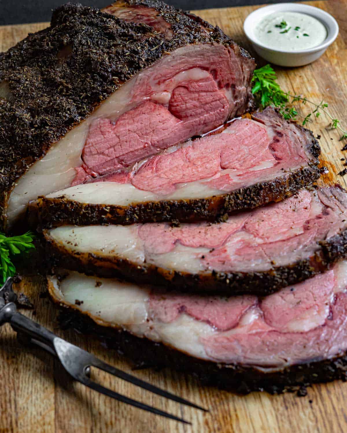 Prime rib roast with three slices and a carving fork
