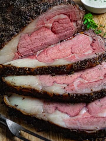 Prime rib roast with three slices and a carving fork