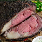 Pinterest pin of moked prime rib with one slice cut on a cutting board
